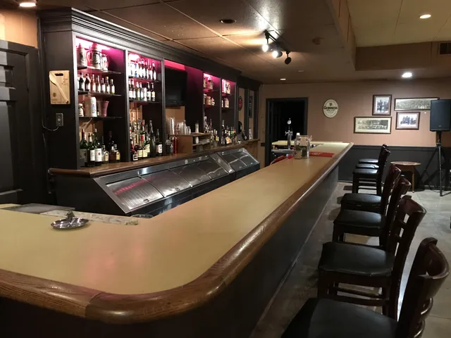 The long wooden bar in the lower level Bar Lounge at McGowan Hall