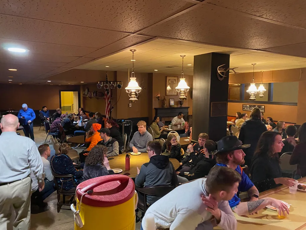 A full room of guests talking and drinking in the warmly lit Bar Lounge