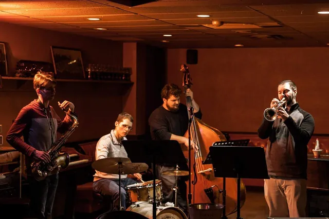 A jazz quartet playing saxophone, drums, bass and trumpet in the Bar Lounge