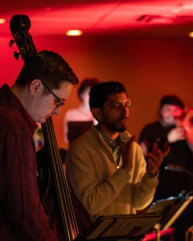 A bassist playing under red light during a live set