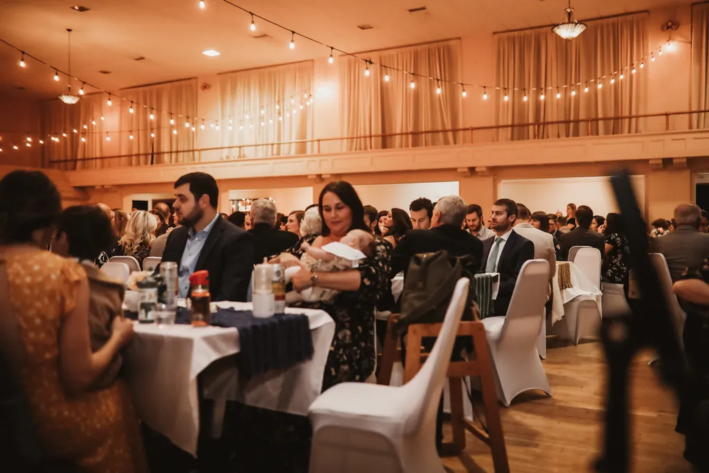 Guests seated for dinner service at round tables in the Grand Hall