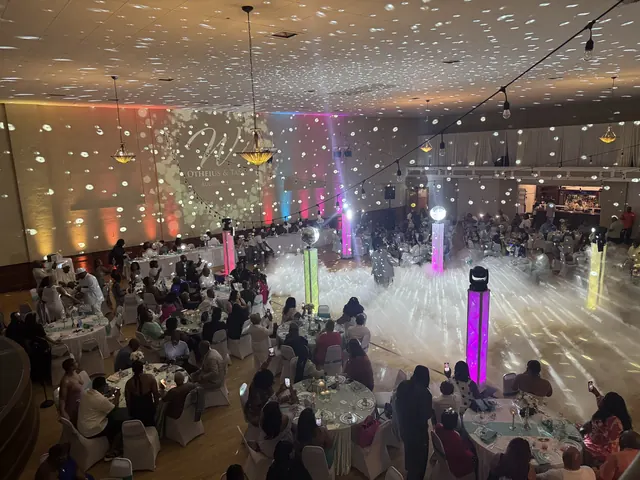 The dance floor covered in low fog with lit columns and guests at round tables all around it