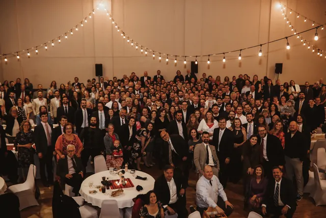 A large group photograph of guests filling the Grand Hall