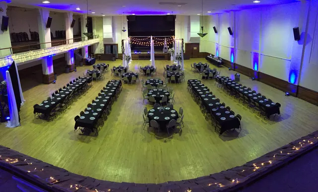 Long banquet tables lit in blue and green across the Grand Hall