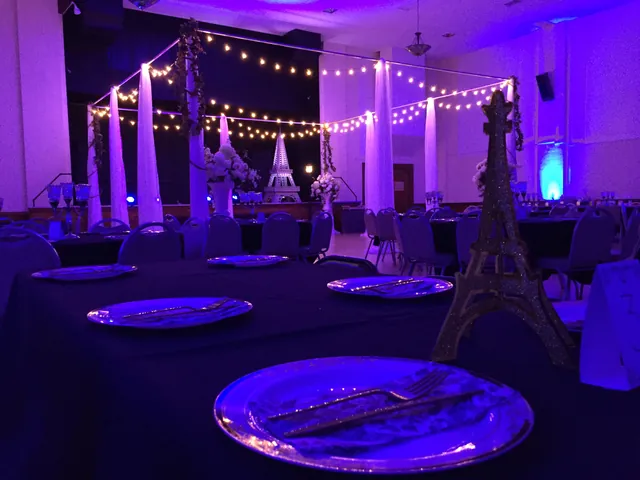 Tables lit in deep purple with an Eiffel Tower centrepiece for a themed party