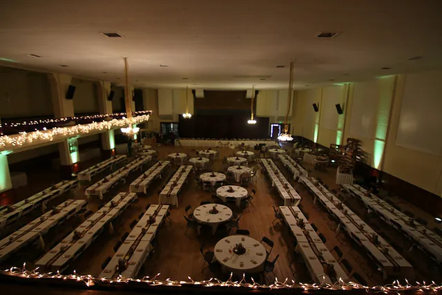 Tables dressed with linens under warm lighting for a mid sized event