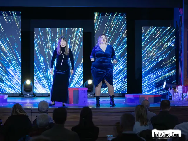 Two singers performing on the Grand Hall stage in front of glittering LED panels while the audience watches
