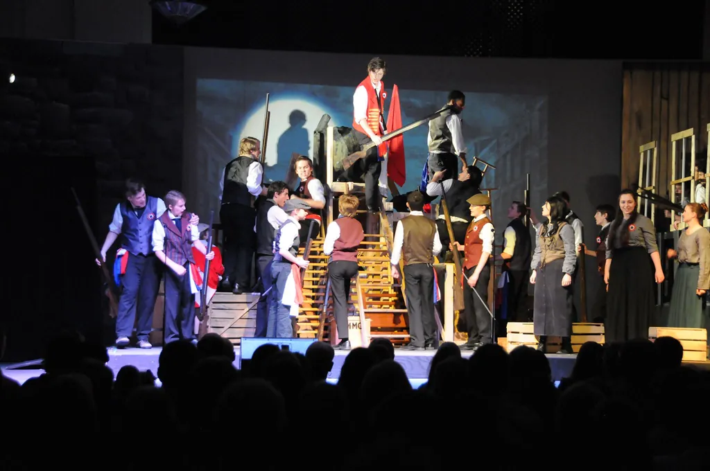 A full cast performing on the stage of the Grand Hall during a theatre production