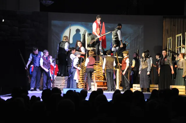 Cast on stage during a theatre production in the Grand Hall