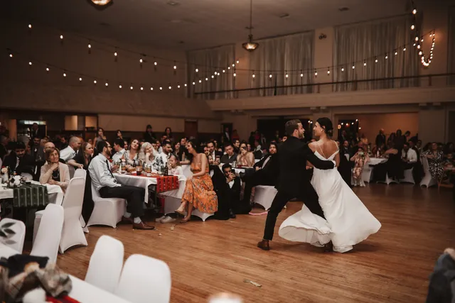 A couple sharing their first dance surrounded by seated guests at McGowan Hall